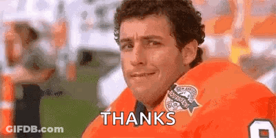 A Man In A Football Uniform Is Sitting On A Field And Saying Thanks . GIF