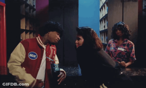 A Man In A Ford Jacket Talks To A Woman In A Pink Shirt GIF
