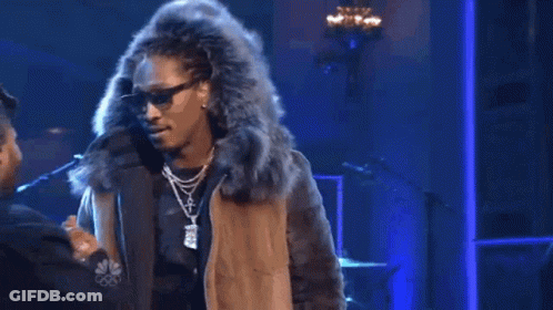 A Man In A Fur Coat Is Shaking Hands With Another Man In A Hat . GIF