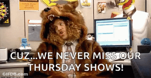A Man In A Fur Coat Is Sitting At A Desk With A Computer . GIF
