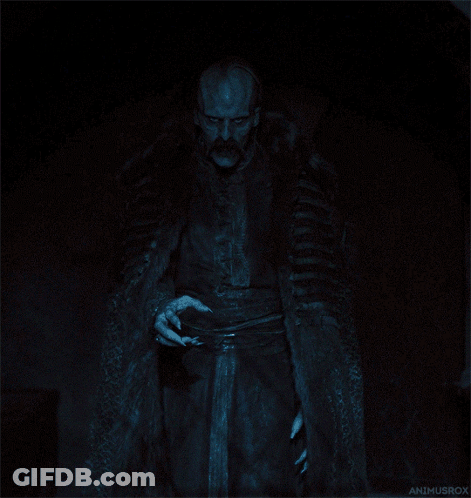 A Man In A Fur Coat Is Standing In The Dark With The Name Animusrox On The Bottom Left GIF