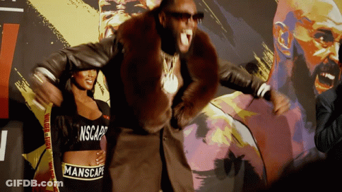 A Man In A Fur Coat Is Standing Next To A Woman Wearing A Manscape Crop Top GIF