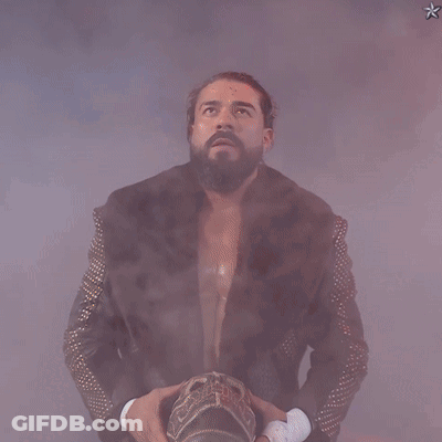A Man In A Fur Coat With Studded Sleeves Is Holding A Crown GIF