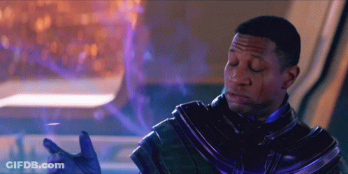 A Man In A Futuristic Suit With His Eyes Closed And His Hands Outstretched GIF