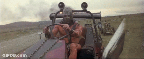 A Man In A Gas Mask Is Driving A Vehicle GIF