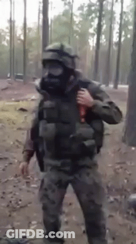 A Man In A Gas Mask Is Holding A Bottle In His Hand GIF