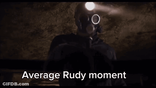 A Man In A Gas Mask Is Holding A Flashlight In A Dark Room With The Words Average Rudy Moment Written Below Him . GIF