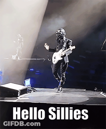 A Man In A Gas Mask Is Playing A Guitar On A Stage With The Words Hello Sillies Above Him GIF