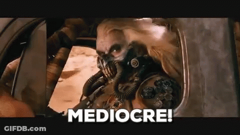 A Man In A Gas Mask Is Sitting In A Car With The Words Mediocre Written On The Bottom . GIF