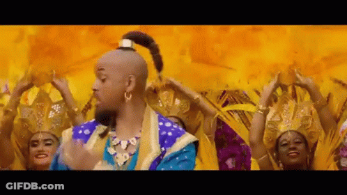 A Man In A Genie Costume Is Dancing In Front Of A Group Of Women . GIF