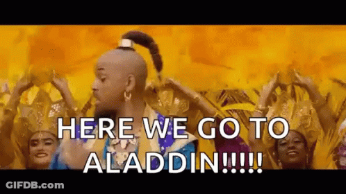 A Man In A Genie Costume Is Standing In Front Of A Group Of Women Dancing . GIF