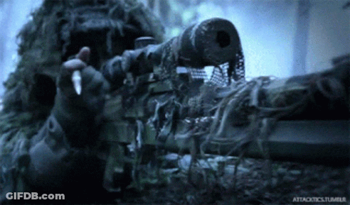 A Man In A Ghillie Suit Holding A Sniper Rifle With Attacktics.tumblr Written On The Bottom GIF