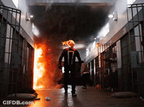 A Man In A Ghost Rider Costume Walks Through A Prison GIF