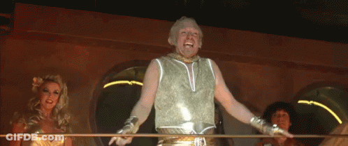 A Man In A Gold Tank Top Is Standing In Front Of Two Women GIF