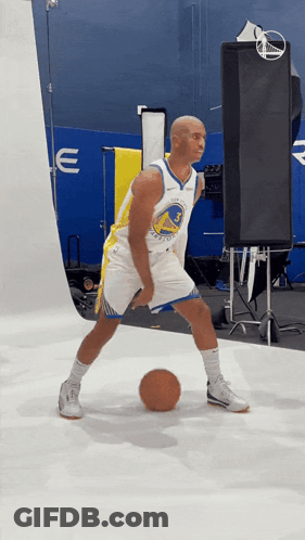 A Man In A Golden State Warriors Jersey Is Dribbling A Ball GIF