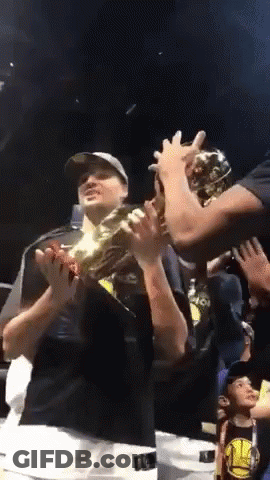 A Man In A Golden State Warriors Shirt Holds Up A Trophy GIF