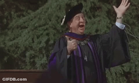 A Man In A Graduation Cap And Gown Is Giving A Speech With His Arms Outstretched . GIF