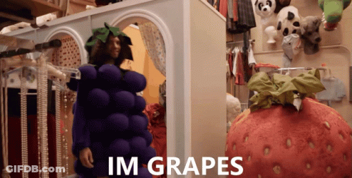 A Man In A Grape Costume Stands Next To A Giant Strawberry Costume GIF