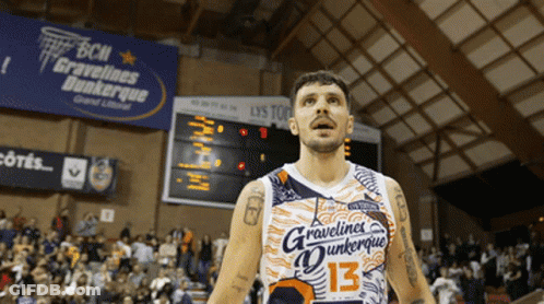 A Man In A Gravelines Dunkerque Jersey Stands In Front Of A Crowd GIF