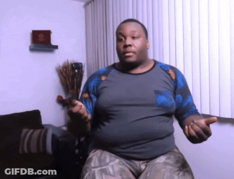A Man In A Gray And Blue Shirt Is Holding A Sword GIF