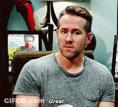 A Man In A Gray Shirt Is Sitting In A Chair And Saying Great GIF