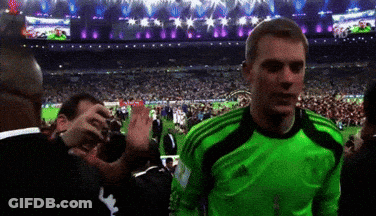 A Man In A Green Adidas Jersey Stands In Front Of A Crowd Of People GIF