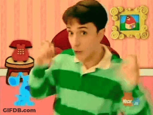 A Man In A Green And Blue Striped Shirt Is Standing In Front Of A Pink Wall With A Picture Of A House On It . GIF