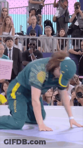 A Man In A Green And Yellow Outfit With Australia On It Is Kneeling Down In Front Of A Crowd GIF