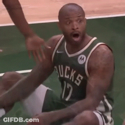 A Man In A Green Bucks Jersey Is Sitting On The Floor GIF