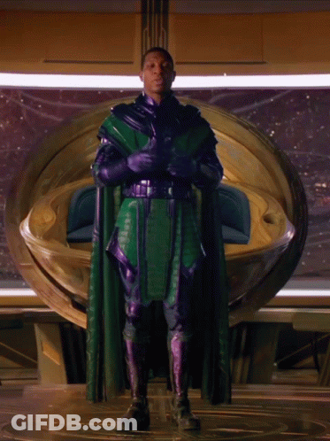A Man In A Green Cape And Purple Gloves GIF