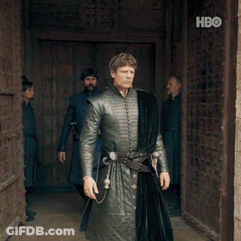 A Man In A Green Coat Stands In Front Of A Door With Hbo Written On It GIF