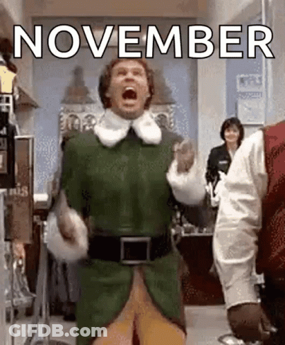A Man In A Green Elf Costume Is Screaming In A Room With The Words `` November '' Behind Him . GIF