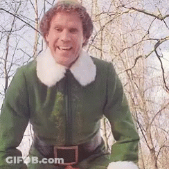 A Man In A Green Elf Costume Is Smiling And Looking At The Camera GIF