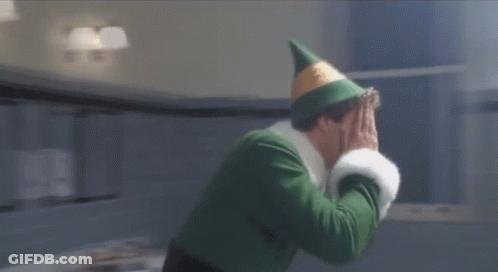 A Man In A Green Elf Costume Is Standing In A Bathroom Next To A Sign That Reads Monday GIF