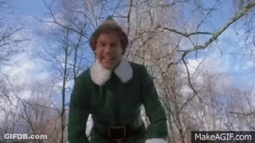 A Man In A Green Elf Costume Is Standing In The Woods . GIF
