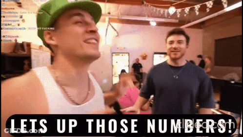 A Man In A Green Hat Is Standing Next To Another Man With The Words Lets Up Those Numbers On The Bottom GIF