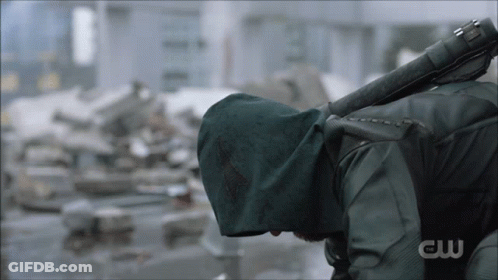 A Man In A Green Hooded Jacket Is Holding A Sword With The Letters Cw On The Bottom GIF
