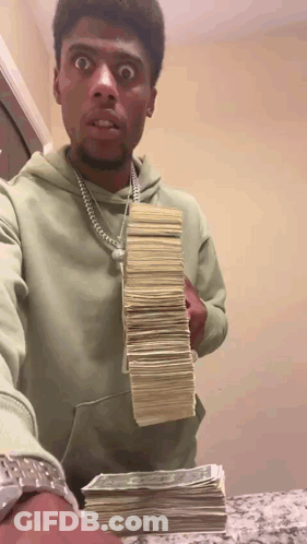 A Man In A Green Hoodie Is Holding A Stack Of Money .. GIF