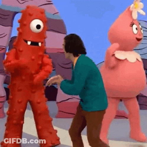 A Man In A Green Jacket Is Dancing With Two Cartoon Characters .. GIF