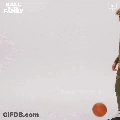 A Man In A Green Jacket Is Holding A Basketball In His Hand . GIF