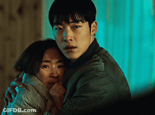 A Man In A Green Jacket Is Hugging A Woman In A White Coat GIF