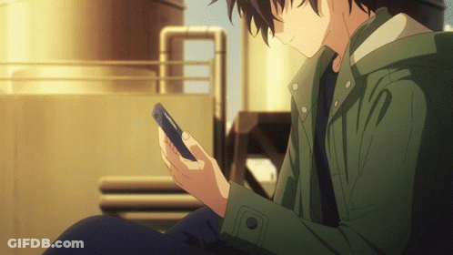 A Man In A Green Jacket Is Looking At A Phone GIF