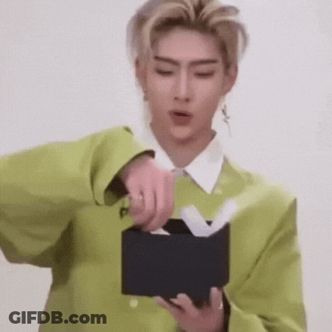 A Man In A Green Jacket Is Opening A Black Box With Tissues In It . GIF