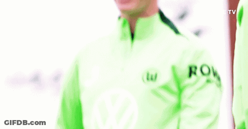 A Man In A Green Jacket Is Smiling And Holding His Arms Up . GIF