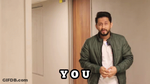 A Man In A Green Jacket Stands In Front Of A Door That Says You On It GIF