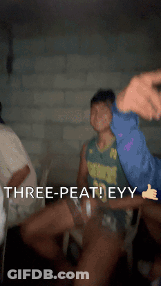 A Man In A Green Jersey Says " Three-Peat Eyy " In A Dark Room GIF