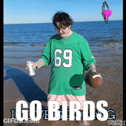 A Man In A Green Jersey With The Number 69 Is Holding A Football GIF