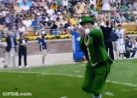 A Man In A Green Leprechaun Costume Is Throwing A Football On A Field GIF