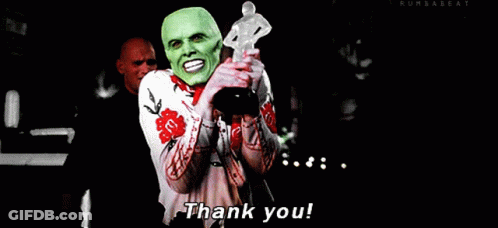 A Man In A Green Mask Is Holding A Trophy And Saying Thank You GIF
