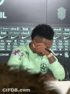 A Man In A Green Nike Shirt Is Covering His Eyes With His Hand GIF